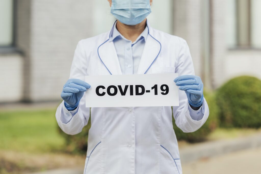 close-up-doctor-holding-covid-sign